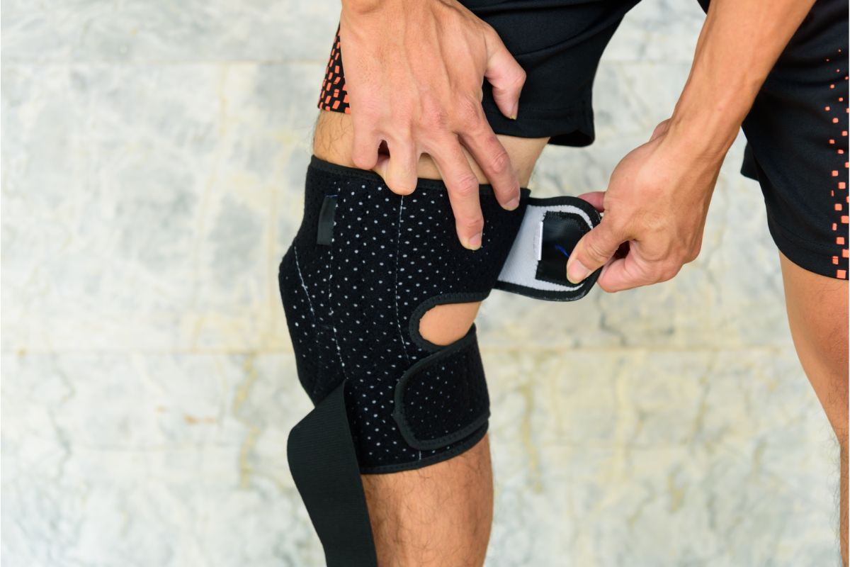 Picture of man putting on a knee brace.