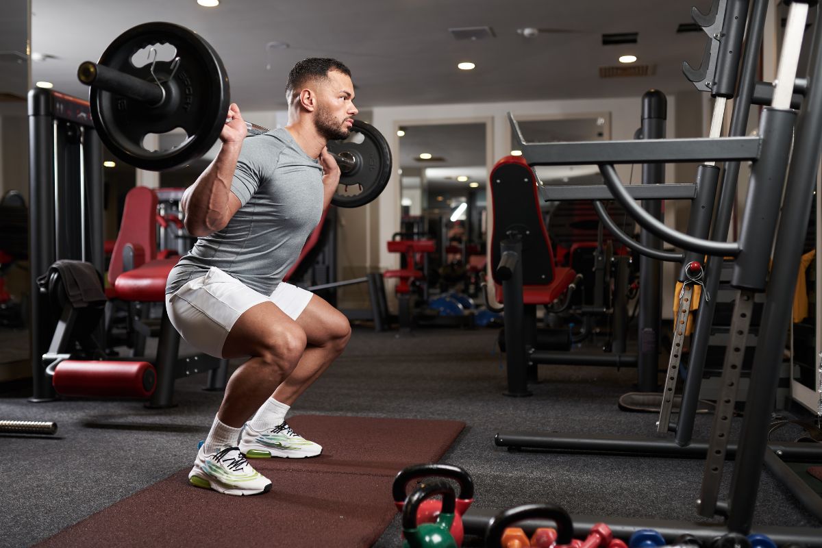 Man doing barbell squats.